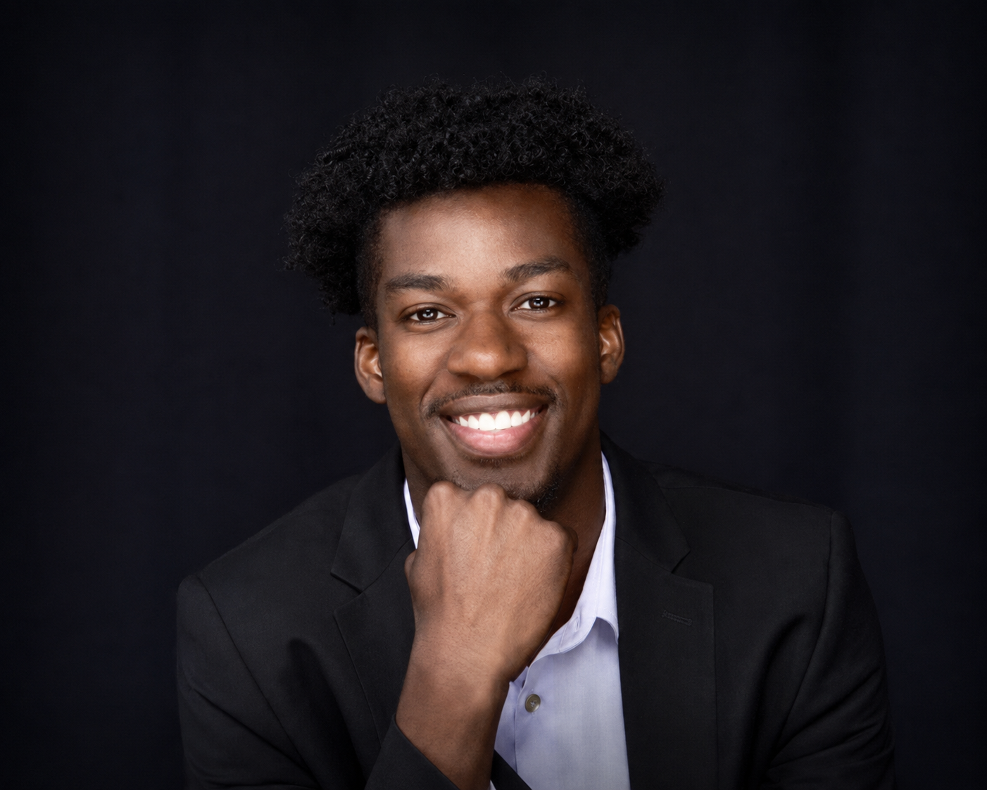 Chris Inkum smiling, with his chin resting on his hand